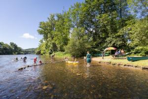 um grupo de pessoas na margem de um rio em Huttopia Beaulieu sur Dordogne em Beaulieu-sur-Dordogne