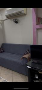 a blue couch in a living room with a laptop at Chalet in Ain Sokhna