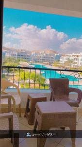 a balcony with chairs and tables and a view of a city at Chalet in Ain Sokhna