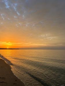 a sunset on a beach with the ocean at Velvet in Perea +4 photos