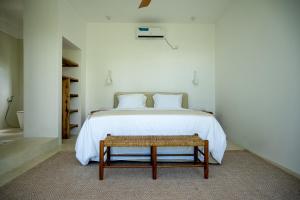 a bedroom with a bed with a bench next to it at Villa Vera in Ahangama