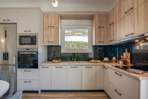a kitchen with white cabinets and a window at Casa Elea in Kissamos