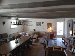 a living room with a large wooden table and chairs at Le Mas des Baux in Bédoin