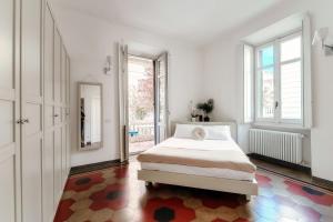 een witte slaapkamer met een bed en een spiegel bij Cedro Apartment by Quokka 360 - designer flat in Como in Como