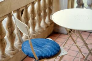 een witte tafel en een stoel met een blauwe zitting bij Cedro Apartment by Quokka 360 - designer flat in Como in Como +25 foto's