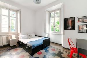 een slaapkamer met een bed in een kamer met ramen bij Cedro Apartment by Quokka 360 - designer flat in Como in Como