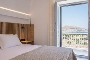 a bedroom with a bed and a large window at Blue Mare Villas in Naousa +126 photos