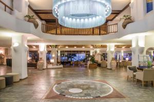 a large lobby with a large chandelier in the middle at Coral Beach Hotel & Resort Cyprus in Coral Bay
