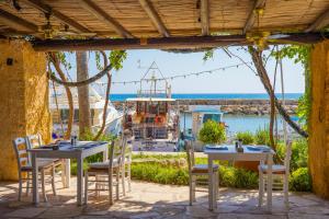 a table with chairs and a boat in a marina at Coral Beach Hotel & Resort Cyprus in Coral Bay