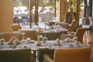 a dining room with tables and chairs with wine glasses at Coral Beach Hotel & Resort Cyprus in Coral Bay