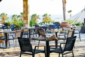 a row of tables and chairs on a patio at Coral Beach Hotel & Resort Cyprus in Coral Bay