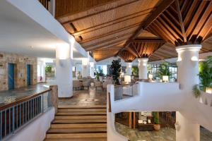 a lobby of a resort with wooden ceilings and tables at Coral Beach Hotel & Resort Cyprus in Coral Bay