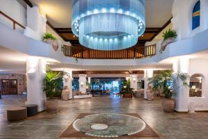 a large lobby with a large blue chandelier at Coral Beach Hotel & Resort Cyprus in Coral Bay