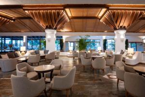 a lobby of a hotel with tables and chairs at Coral Beach Hotel & Resort Cyprus in Coral Bay