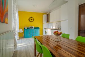 a kitchen with a wooden table and green chairs at Casa LUIS in Luino