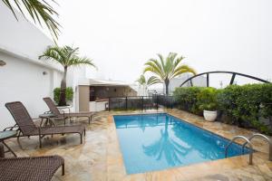 una piscina en un patio con sillas y palmeras en Augusto's Rio Copa Hotel, en Río de Janeiro