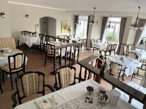 a dining room with tables and chairs in a restaurant at Hotel Seerose Bad Malente in Malente