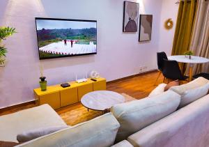 a living room with a couch and a flat screen tv at La Parenthèse T2 au Vallon près Rue des Jardins in Abidjan