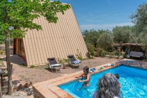 a group of people playing in a swimming pool at Cabaña Triangulo - Tierra de Arte in San Jorge