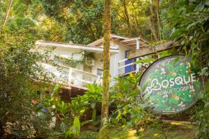 a house in the woods with a sign in front of it at BOSQUE TOQUE TOQUE Pousada in São Sebastião