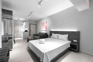 sypialnia z dużym białym łóżkiem i kanapą w obiekcie Modeco, Nilie Hospitality MGMT w Salonikach