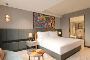 a bedroom with a large white bed and a couch at Crowne Plaza Lucknow by IHG in Lucknow