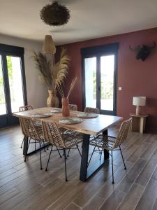 a dining room with a wooden table and chairs at La Maison Zanzibar in Lavilletertre