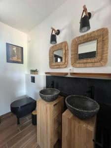 a bathroom with two sinks and two mirrors at La Maison Zanzibar in Lavilletertre