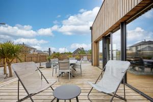 una terrazza con sedie, tavolo e sedie di La Bouteille à la Mer-Maison darchitecte jacuzzi a Barneville-Carteret