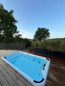 a hot tub sitting on a wooden deck at La Maison Zanzibar in Lavilletertre