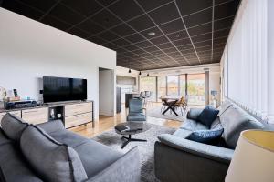un soggiorno con due divani e una TV di La Bouteille à la Mer-Maison darchitecte jacuzzi a Barneville-Carteret