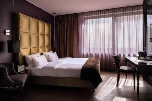 a hotel room with a large bed and a desk at Roomers Frankfurt Central, Autograph Collection in Frankfurt/Main