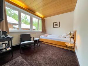 una camera da letto con un letto, una scrivania e una sedia di Hotel Berghof a Seefeld in Tirol