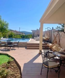 a patio with chairs and tables and a pool at Villa Nilić in Bar