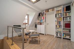a living room with a chair and bookshelves at Ferienwohnung Am Höpen in Rechlin