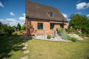 a brick house with a garden in front of it at Ferienwohnung Am Höpen in Rechlin