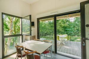 uma sala de jantar com mesa e cadeiras e uma varanda em Huttopia Beaulieu sur Dordogne em Beaulieu-sur-Dordogne
