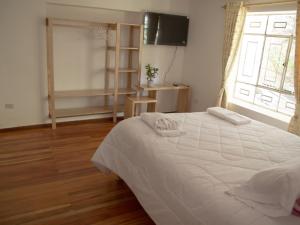 ein Schlafzimmer mit einem weißen Bett und einem Fenster in der Unterkunft Host Apart Casa Bella in Cajamarca