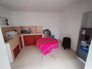 eine Küche mit einem Tisch und einer rosa Decke darauf in der Unterkunft Host Apart Casa Bella in Cajamarca + 6 Fotos