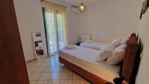 a bedroom with two beds and a window at Nicole House in Agia Effimia