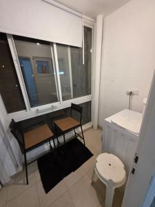エルサレムにあるJerusalem apartmentのテーブルと椅子2脚と窓のある部屋 +14枚の写真
