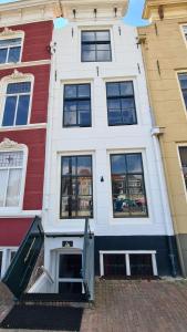 a red and white building with an open door at Havenzicht in Vlissingen