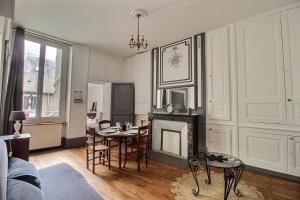 ブールジュにあるLe Logis d'Henri by PRIMO C0NCIERGERIEのテーブルと暖炉のあるリビングルーム