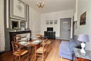 ブールジュにあるLe Logis d'Henri by PRIMO C0NCIERGERIEのテーブルと青いソファのあるリビングルーム +3枚の写真