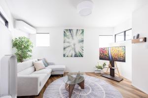 a white living room with a couch and a table at First Choice in Tokyo