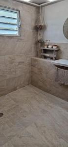 a bathroom with a tiled floor and a sink at Le temps d'un repos in Vieux-Habitants