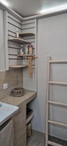a walk in closet with a sink and shelves at Le temps d'un repos in Vieux-Habitants +35 photos