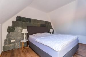 a bedroom with a large bed with a stone wall at Wellness Vakantiehuis in Yerseke in Yerseke