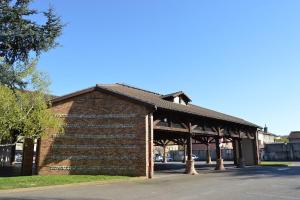 a brick building with a pavilion on a street at Le Loft de Genas centre Bourg in Genas +42 photos