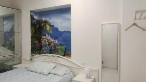 a bedroom with a large painting on the wall at On The Beach SORRENTO in Massa Lubrense